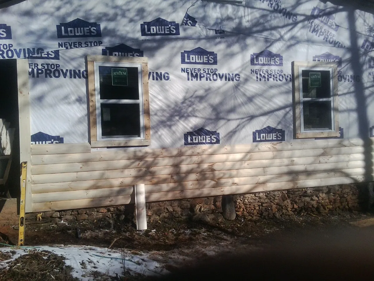 House wrap and new log siding going up on an exterior wall in Dallas