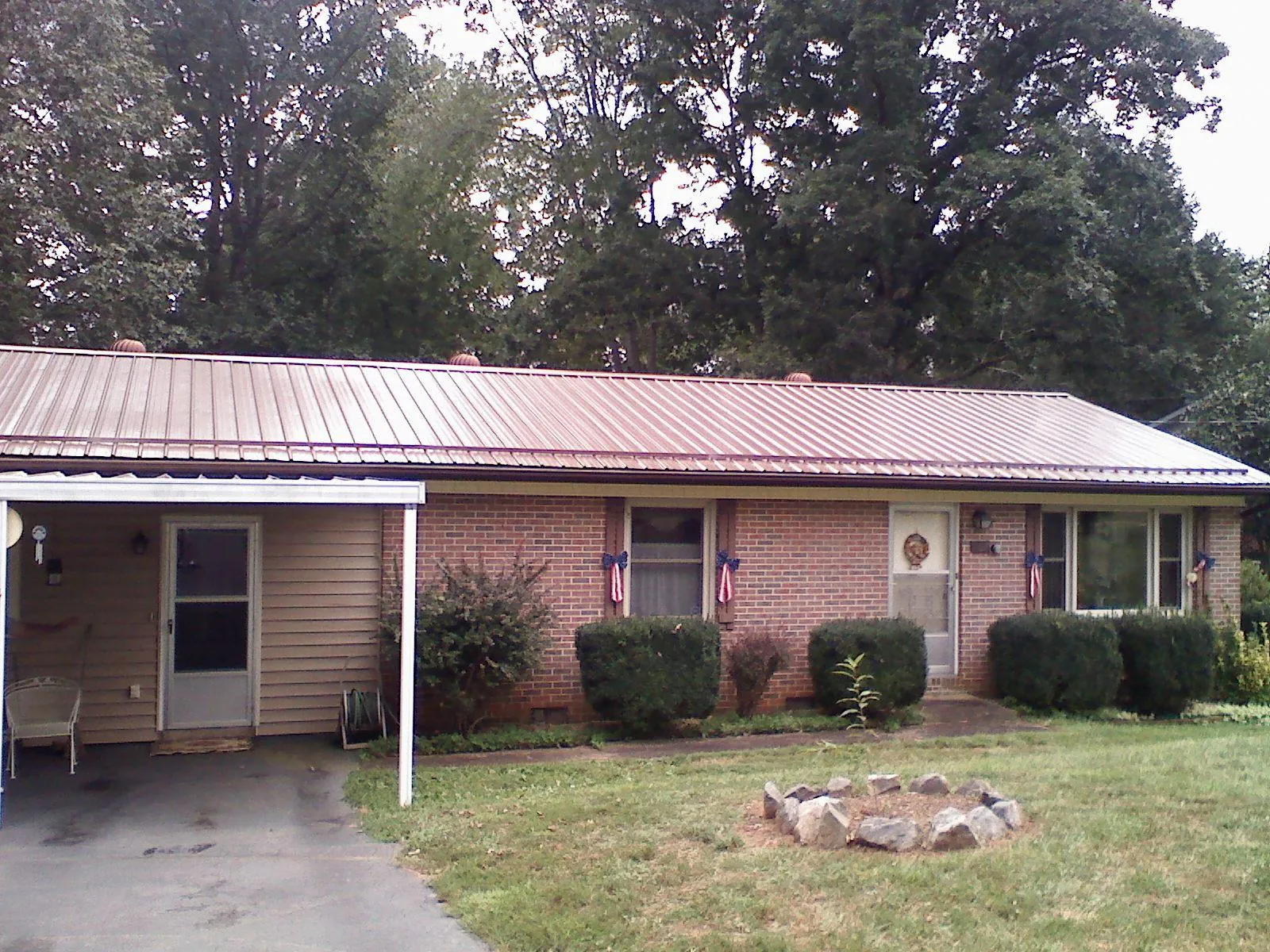 Bronze metal roof and carport on a brick ranch home — Roof Repair work by our crew in Dallas